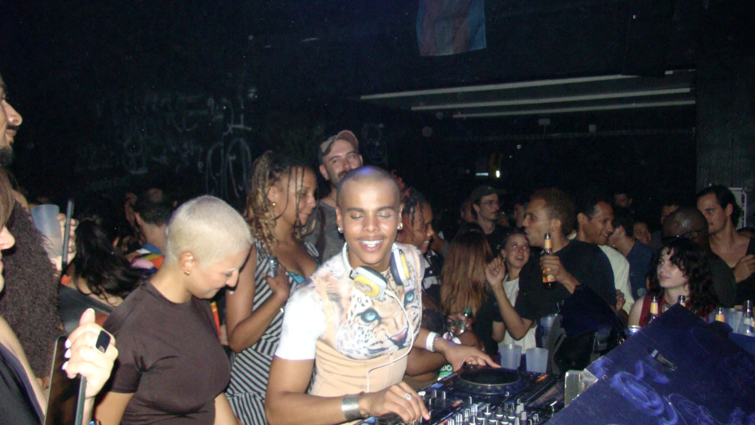 Oluwa smiling at the decks at Daddy Issues, the crowd packed behind him