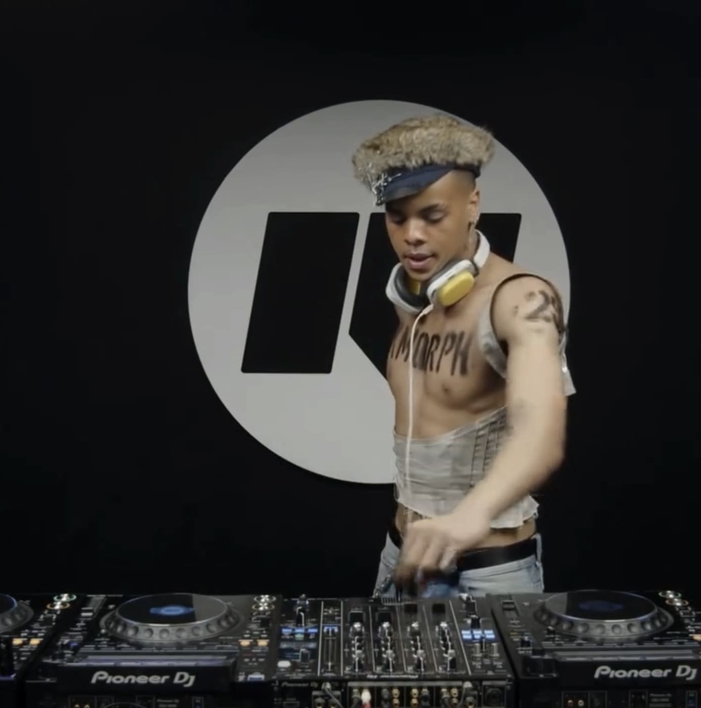 Oluwa at the decks in the Rinse studio, the R roundel behind him