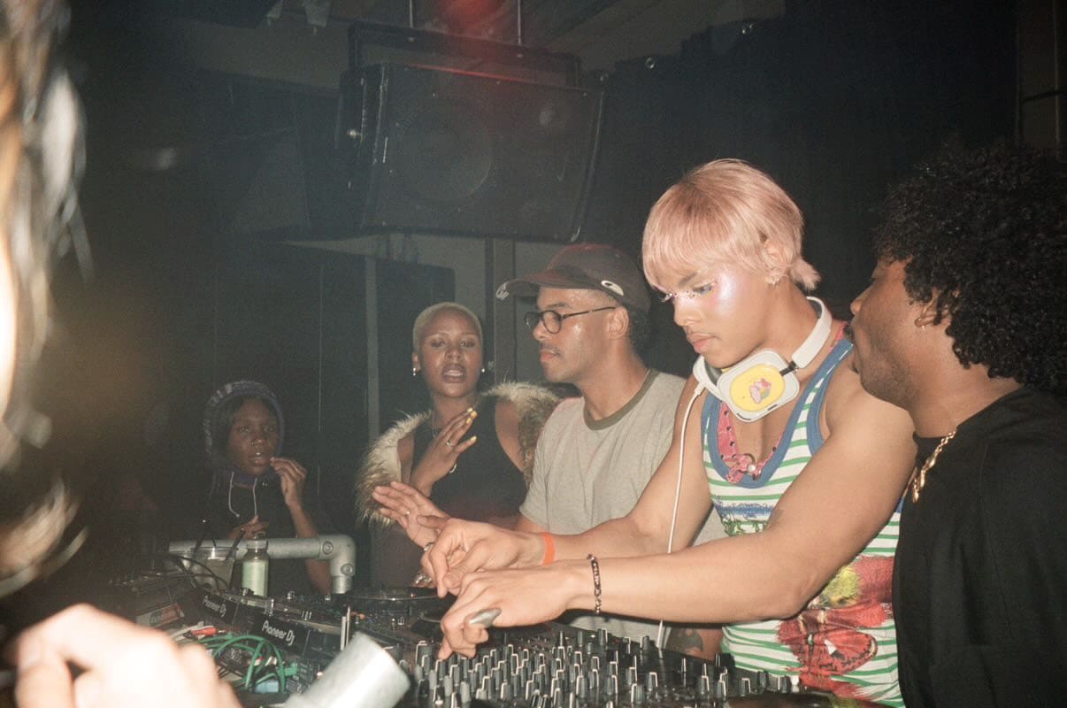 Oluwa at the decks mid-set at Uway, the floor moving around him